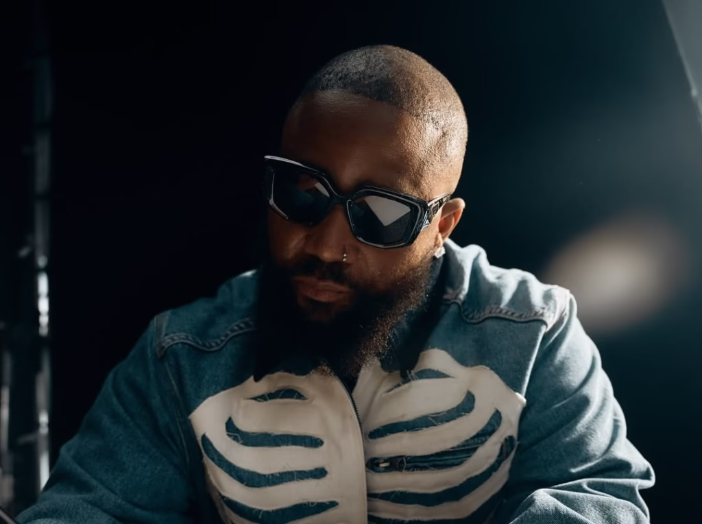 Stylish man wearing sunglasses and denim jacket in music studio for SlikourOnLife.